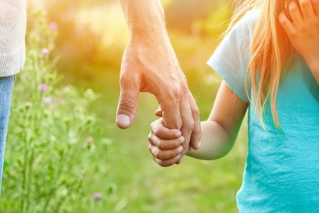 Child holding hands with parent